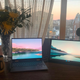 A laptop and portable monitor sit side-by-side on a desk.